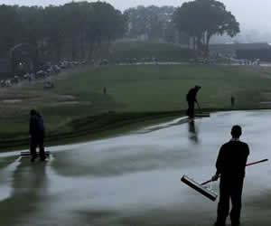 Asistentes retiran agua del campo; Foto: EFE