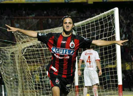 Martínez festeja el tercer gol del encuentro. Foto: Luis Robayo Juan Manuel Martínez convirtió tres goles en una noche de ensueño. Fue figura y se fue ovacionado por los 42.000 hinchas que asistieron al estadio ‘General Santander’. El gol era una materia pendiente de Juan Manuel Martínez con el Cúcuta Deportivo. Desde su debut en el equipo, por la cuarta fecha del torneo Apertura ante Millonarios el 7 de marzo, se propuso convertir, pero solo hasta el 24 de abril, en Ibagué, contra Deportes Tolima logró ese objetivo. Aquella noche mágica donde se obtuvo la clasificación a estos octavos de final de la Copa Libertadores tras vencer 3-4. Pero la noche del 3 de mayo no la podrá olvidar jamás. El ‘Burrito’ se puso el traje de goleador. A sus jugadas individuales y desbordes claves le agregó el gol. En el juego de ida por los octavos de final ante Toluca anotó tres veces. Puso de pie a los 42.000 aficionados que dejaron sus manos rojas de tanto aplauso que generó. La historia comenzó cuando al minuto 32 Martínez pateó afuera del área y mandó la pelota adentro. Dos segundos antes le habían cometido falta a Bustos de Palencia, pero el argentino tomó el rebote y la puso en un ángulo donde Cristante no llegó. Él segundo gol del Cúcuta, el del uruguayo Castro, lo tuvo a Martínez como uno de los hombres que participó en la acción. Pero la mejor acción de la noche lo tuvo a él como principal protagonista. El reloj informaba que iban 41 minutos de juego y tras una rápida acción ofensiva en donde a Alex Del Castillo se le complicó patear y prefirió dejarle la pelota al veloz atacante pues fue allí donde el ‘Burrito’ mostró sus virtudes. Dominó el balón con pierna derecha, engañó a dos defensores con un amague, encaró al arquero Cristante, levantó su cabeza para observar su ubicación y definió con pierna izquierda con un toque suave que sirvió para acariciar la pelota y poner a delirar a cada una de las tribunas abarrotadas de gente. Era el mejor momento de una función histórica. Pero faltaba más porque al minuto 45, otra vez él, Martínez, ganó con su pique veloz. Superó la marca de Emilio Hassan quien observó como Martínez, con pierna derecha, empujaba la pelota junto a la fuerza de todos los hinchas que saltaban y no podían creer lo que estaban observando. Fueron 14 minutos inolvidables para los hinchas. Para el Cúcuta Deportivo y, claro, para Juan Manuel que convirtió tres goles para escribir una historia llena de emoción, vértigo y mucha precisión. En la segunda parte, el protagonista de la obra recogió los aplausos. Cada pelota que tocó fue una ovación permanente que se magnificó cuando al minuto 80 fue reemplazado por Lionard Pajoy. La gente se puso de pie, entonó ese grito ausente de “Ar-gen-ti-no/ Ar-gen-ti-no/ Ar-gen-ti-no/ Ar-gen-ti-no”, que sirvió para darle la bienvenida a ese rincón privilegiado que cada hincha tiene reservado para los jugadores que marcan momentos y dejan un grato recuerdo en su memoria. El bautizo a un nuevo ídolo cucuteño ya era un hecho en un ‘templo’ que hervía de emoción y vivía un momento único. Por: Leonardo Duque, Periodista Fútbol - www.colombia.com
